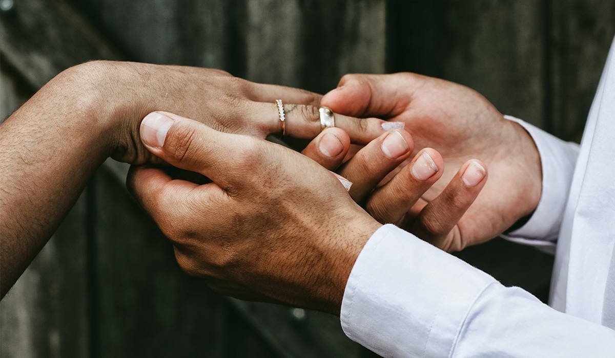 Мужчина одевает кольцо на руку девушки