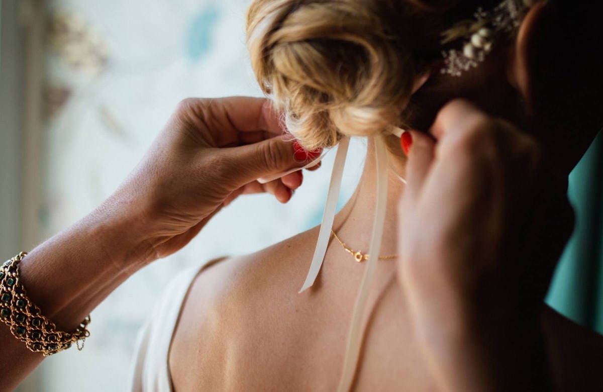 Невесте завязывают ленту на причёске